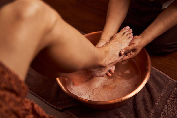 istock Experienced chiropodist washing foot in special container in spa salon 1323514213