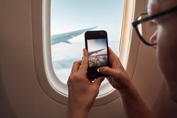 istock Passenger photographing through airplane window 1323514745