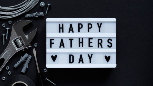 Happy Fathers Day banner concept.Working repair tools upholstery stapler,screwdriver,screws,adjustable wrench,duct tape and light box with Happy Fathers Day text black background,top view,flat lay concepto de pancarta del feliz día del padre. herramientas de reparación de trabajo tapicería grapadora, destornillador, tornillos, llave ajustable, cinta adhesiva y caja de luz con feliz día del padre texto fondo negro, vista superior, plana endecha.