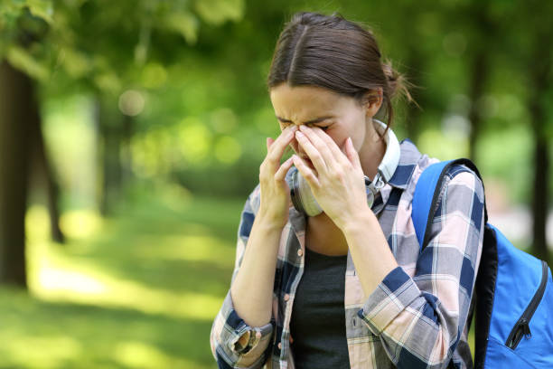 istock Student suffering allergy symptoms scratching eyes in a park 1323517546