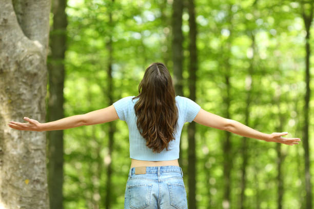 istock Woman outstretching arms in a forest 1323517661