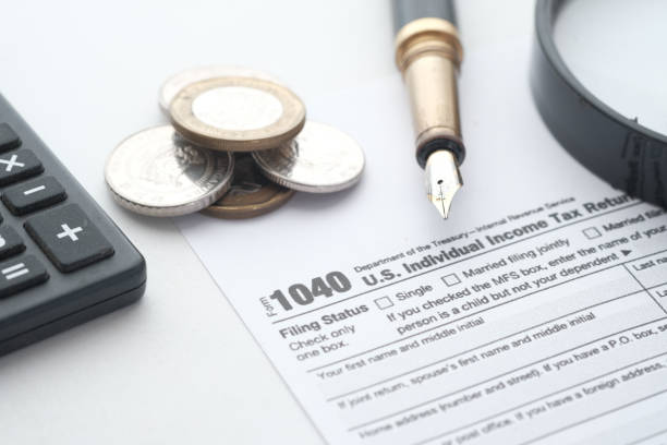 istock Close up of a Tax return form and pen on table. 1323517825