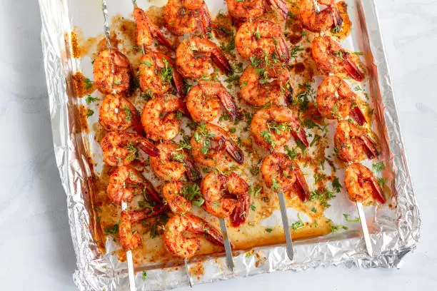Grilled Shrimp Skewers on a Sheet Pan Garnished with Cilantro and Lemon Top Down Photo