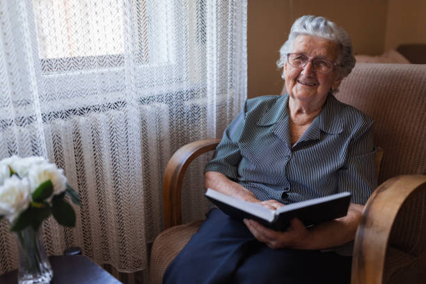 istock Joly grandmother reading a book at home 1323518902