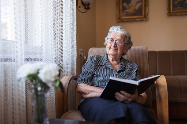 istock Grandmother reading a book at home 1323518924