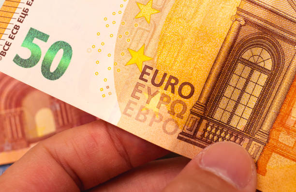 деньги, евро - eur. человек, держащий банкноту евро в руках. примечание 50 евро. - euro paper currency стоковые фото и изображения
