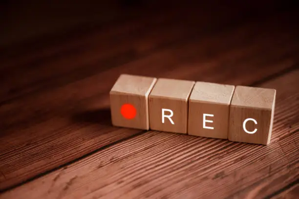 Photo of Text RET on a wooden cube placed on a wooden table with a blurred background.