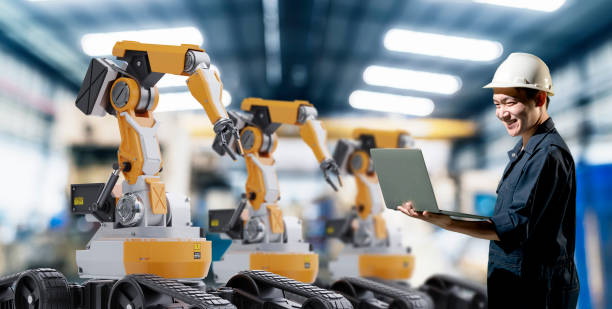 工場でロボットアームマシン産業4.0技術を扱うエンジニア。未来的な革新デジタル技術の生産管理。 - 工場 ストックフォトと画像