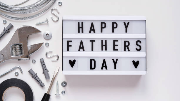 istock Happy Fathers Day banner concept.Working repair tools upholstery stapler,screwdriver,screws,adjustable wrench,duct tape and light box with Happy Fathers Day text white background,top view,flat lay 1323526092