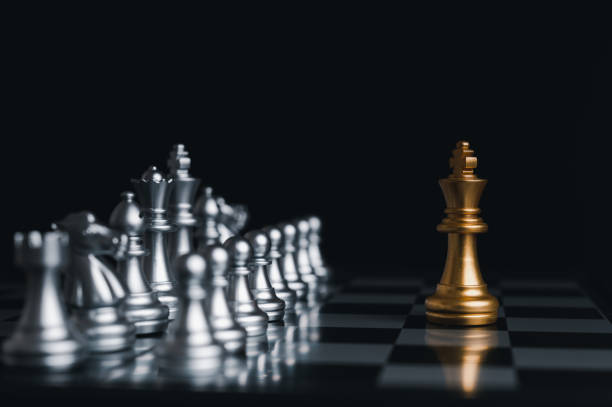 istock Gold king winner surrounded with silver chess pieces on chess board game competition.concept strategy, leadership and success business. 1323526413