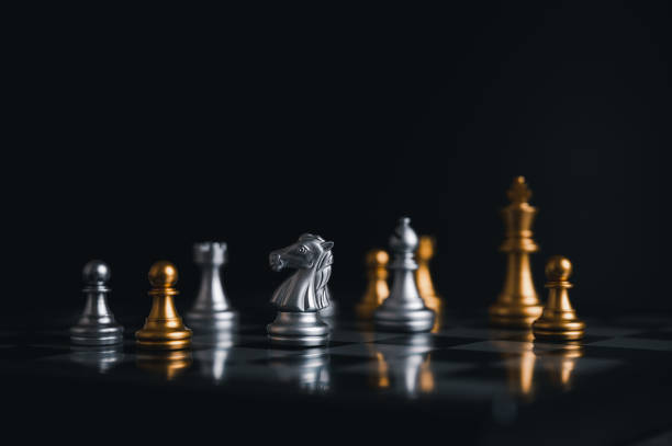 istock Gold king winner surrounded with silver chess pieces on chess board game competition.concept strategy, leadership and success business. 1323526470