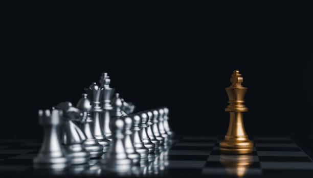 istock Gold king winner surrounded with silver chess pieces on chess board game competition.concept strategy, leadership and success business. 1323526476
