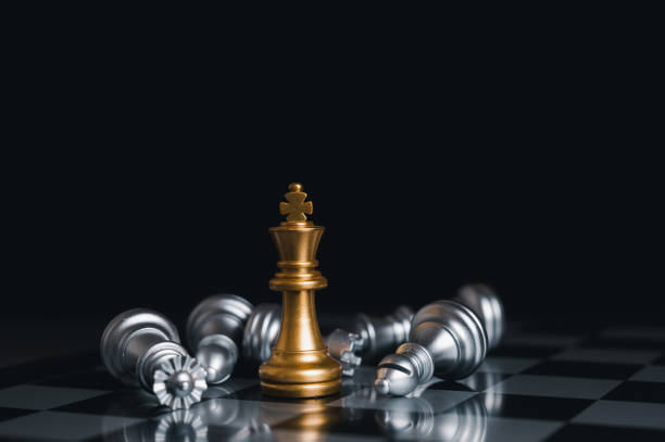 istock Gold king winner surrounded with silver chess pieces on chess board game competition.concept strategy, leadership and success business. 1323526479