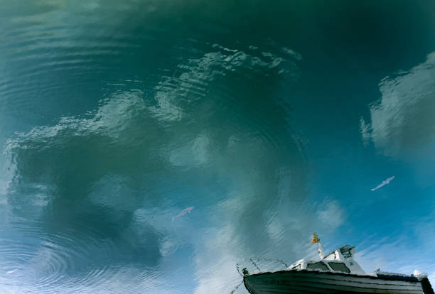istock Reflection on the water of a ship and clouds in a harbor 1323530401