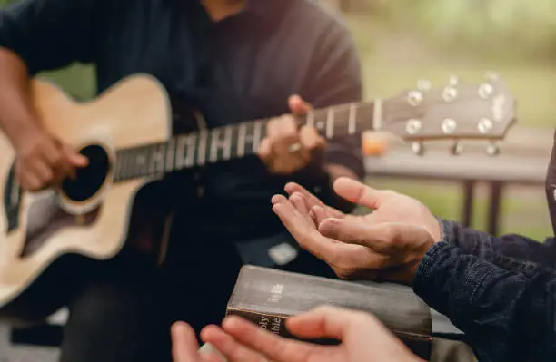 Photo of Christian Families Worshiping God Outdoors To relax life honoring God with a melodious guitar playing and the bible