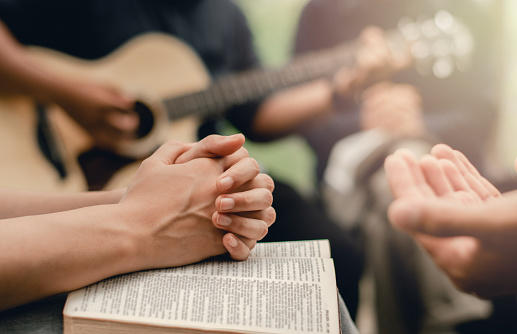 Grupo de oración cristiana con biblia tocando la guitarra para adorar a Dios photo