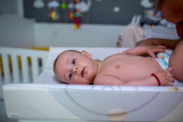 istock Grandfather Changing Diaper To His grandchild 1323531274