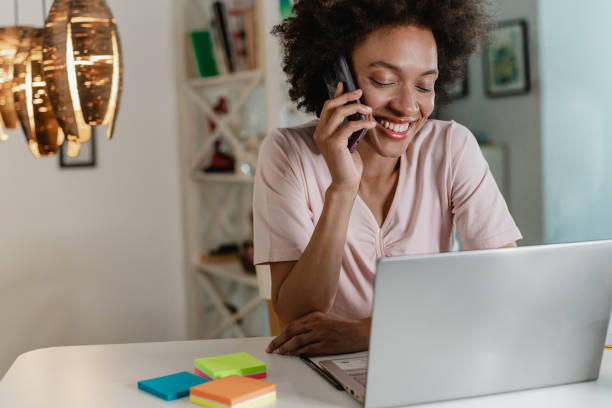 istock Woman is using laptop and talking on the phone 1323533274