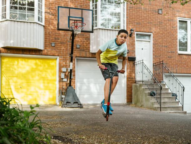 istock Mixed race boy riding scooter in the alley 1323536823