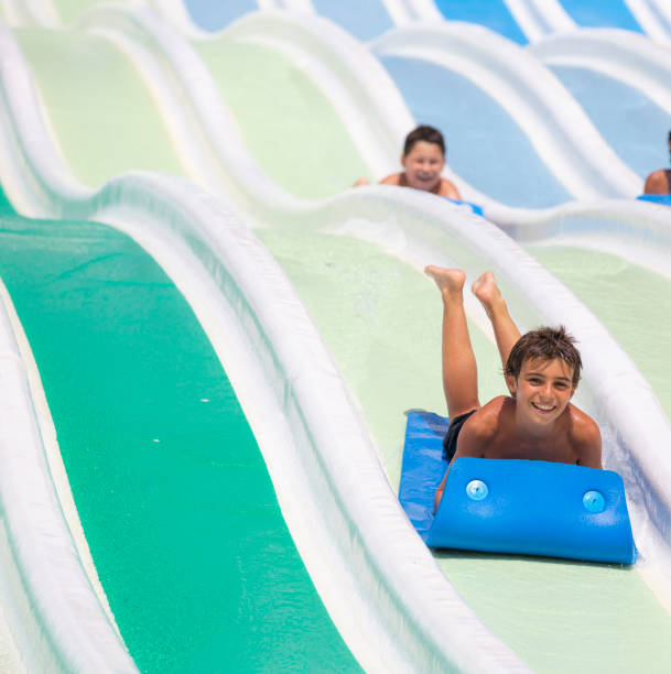 istock kids having fun sliding in water park 1323537828