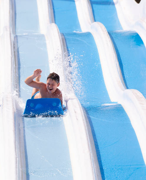 istock kids having fun sliding in water park 1323537833