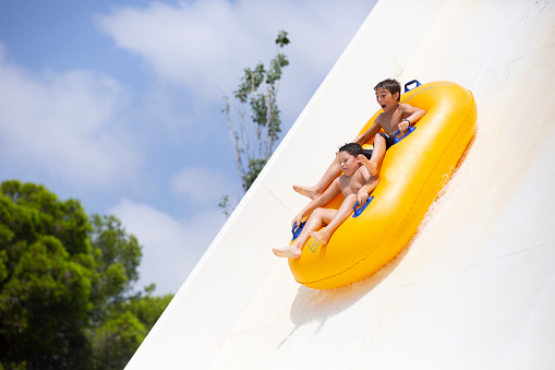 kids having fun sliding in water park located in Torremolinos, Malaga, Spain