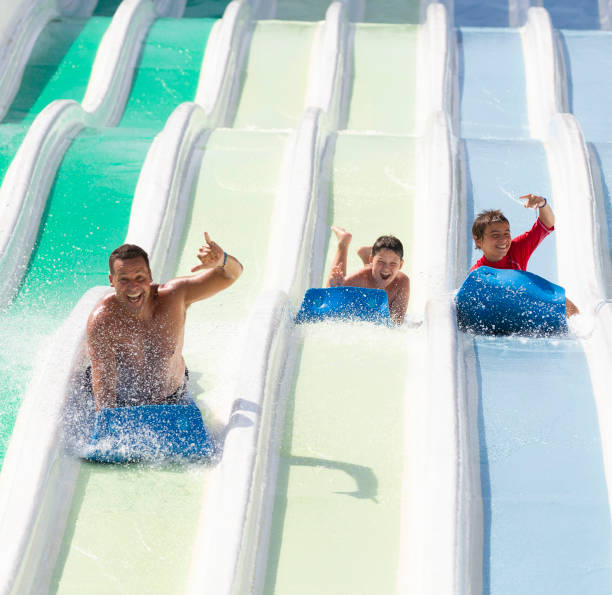 istock kids having fun sliding in water park 1323537840