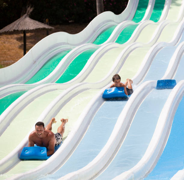 istock kids having fun sliding in water park 1323537854
