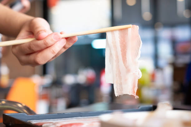 raw sliced bacon with chopsticks for sukiyaki or shabu shabu hot pot, fat meal - buffet japanese cuisine lifestyles ready to eat imagens e fotografias de stock