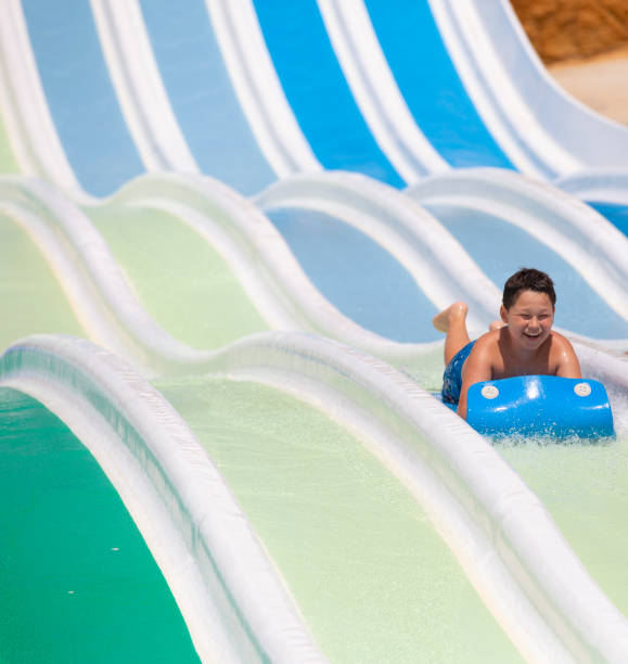 istock kids having fun sliding in water park 1323537937