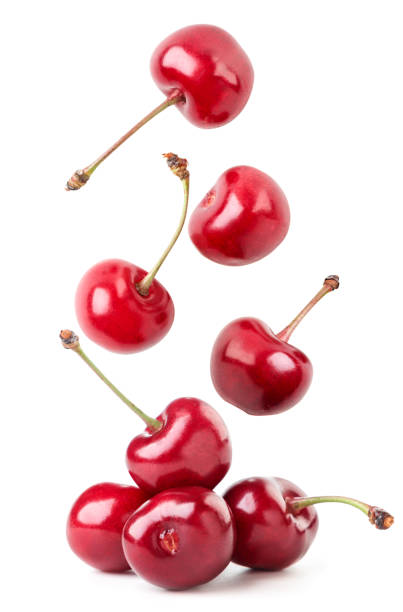 Ripe cherry berries fall on a white background. Isolated Ripe cherry berries fall close-up on a white background. Isolated cherry stock pictures, royalty-free photos & images