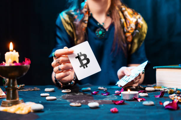 The fortune teller shows a card with the bitcoin currency. The concept of unpredictable cryptocurrency exchange trading The fortune teller shows a card with the bitcoin currency. The concept of unpredictable cryptocurrency exchange trading. magician money stock pictures, royalty-free photos & images