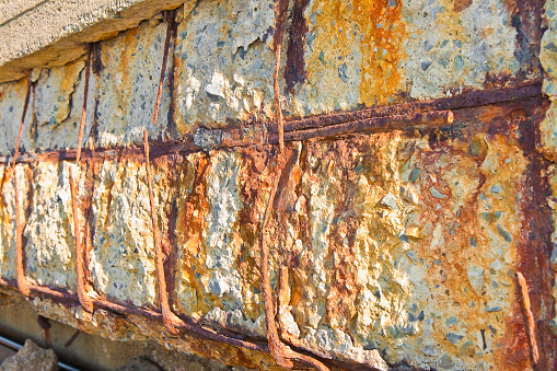 Reinforced concrete with damaged and rusty metallic reinforcement