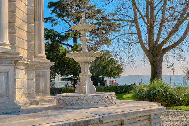inside the dolmabahce palace in istanbul during sunny day in morning with magnificent architectural ornament made by ottoman empire and fountain made of marble stone with bosporus background.