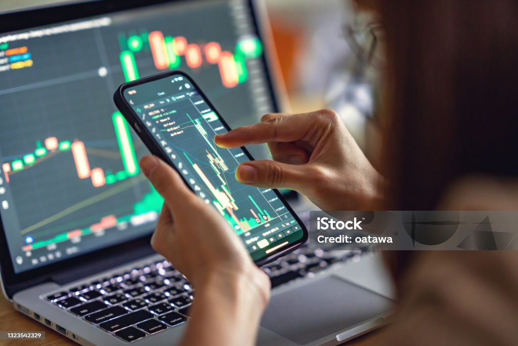 Woman is checking Bitcoin price chart on digital exchange on smartphone, cryptocurrency future price action prediction. Closeup - Woman is checking Bitcoin price chart on digital exchange on smartphone, cryptocurrency future price action prediction. Stock Market and Exchange Stock Photo