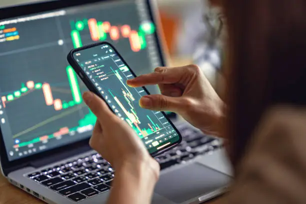 Photo of Woman is checking Bitcoin price chart on digital exchange on smartphone, cryptocurrency future price action prediction.