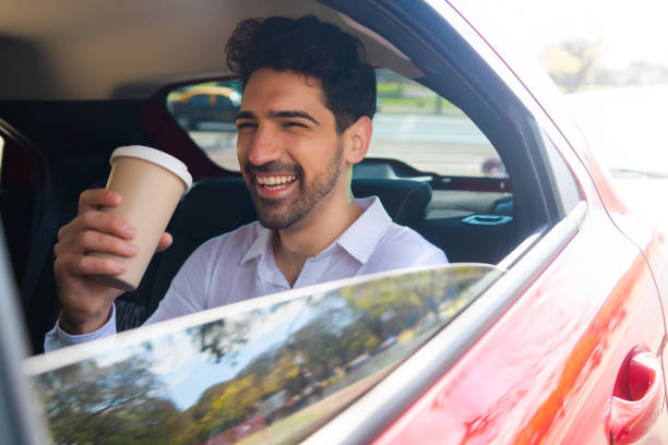 istock Businessman drinking coffee in car. 1323543720