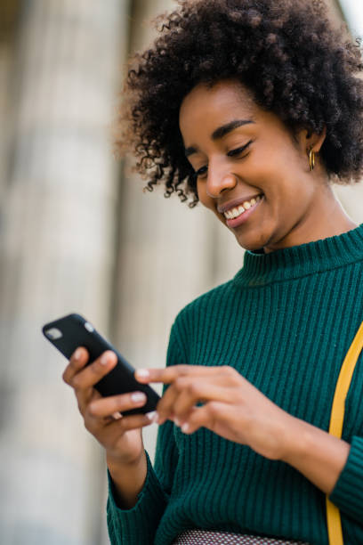 istock Business woman using her mobile phone outdoors. 1323543732