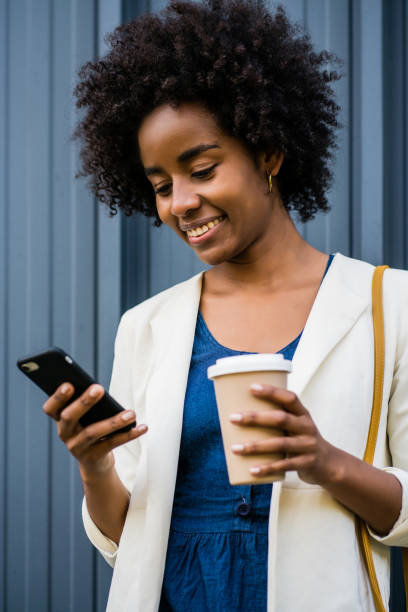 istock Business woman using her mobile phone outdoors. 1323543749