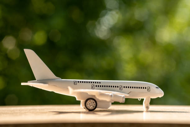 istock Toy white plane. Summer stands on a white wooden background. 1323547196