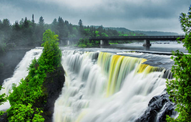 Scemoc main view of Kakabeka Falls Provincial Park in Thunder Bay in a rain and fog with highway bridge in background