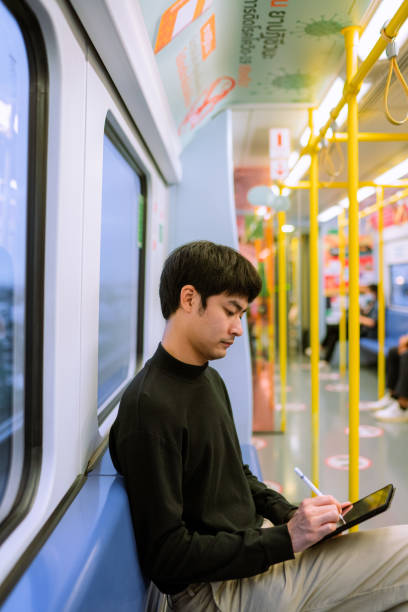 istock asian businessman using laptop in the train to do text messaging 1323547703