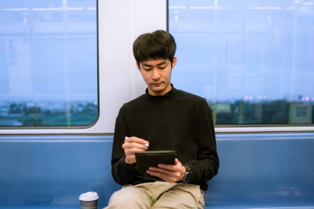 istock asian businessman using laptop in the train to do text messaging 1323547705