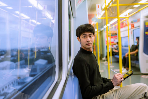 istock asian businessman using laptop in the train to do text messaging 1323547714