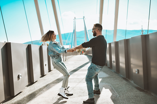 Cute Couple Enjoying Freedom And Dancing On Bridge