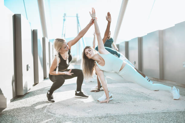 istock Female Fitness Instructor Providing Help For Athletes Struggling With Form During Workout 1323548800