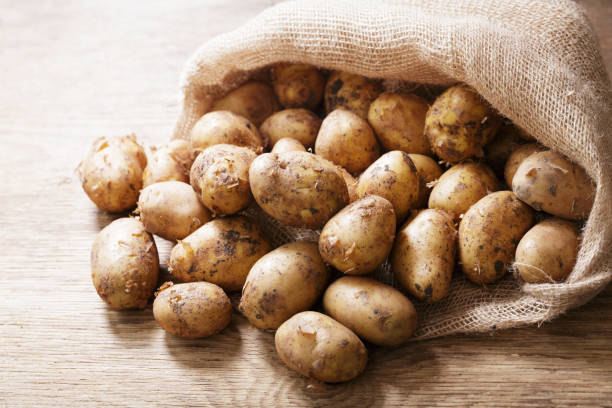 istock fresh potatoes in a sack on a wooden table 1323550097