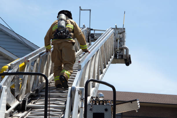 bombeiro em uma escada de emergência brigada de incêndio - house burning color image danger - fotografias e filmes do acervo