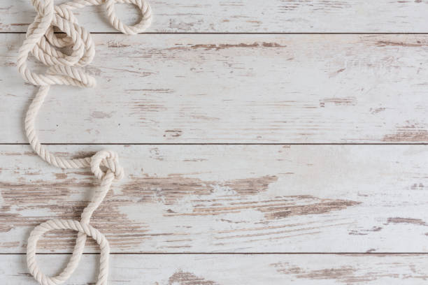 istock Sea background with marine rope on white wooden deck top view. 1323554400