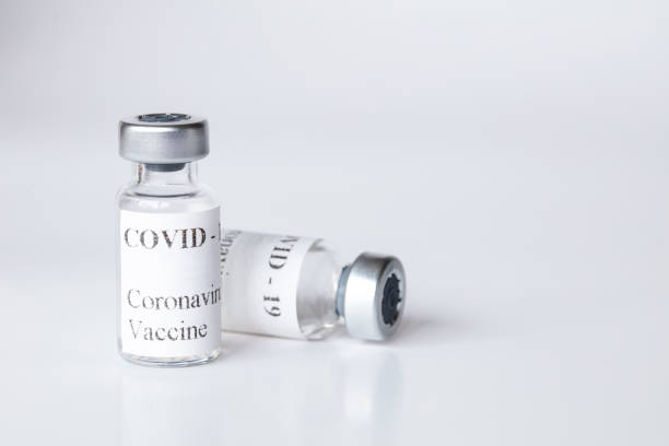 istock Two Empty Covid-19 Vaccine Vials on White Background Close up View 1323554649